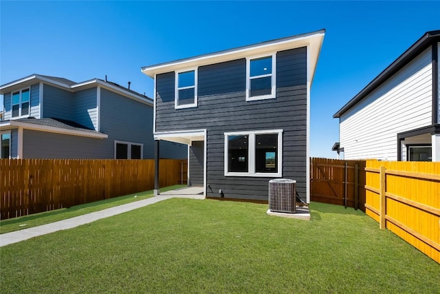 rear view of house featuring a fenced backyard, a lawn, and central AC