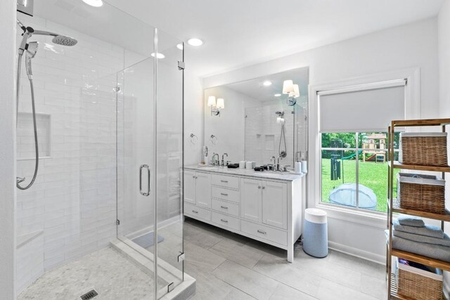 bathroom with double vanity, baseboards, a stall shower, and recessed lighting