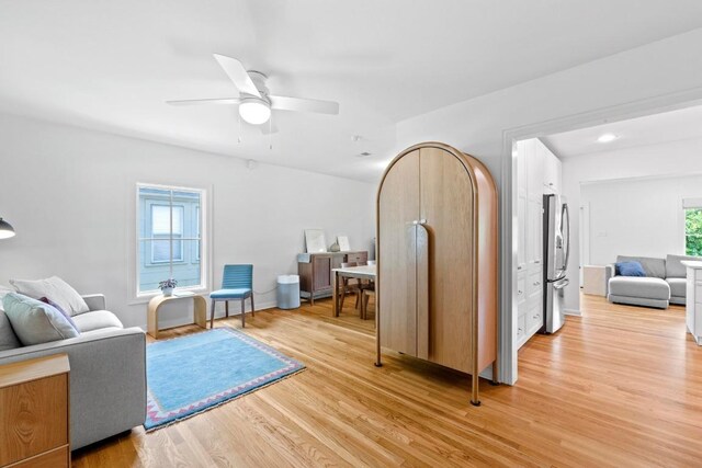 living room with a ceiling fan and light wood-style floors