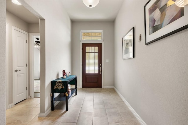 doorway featuring baseboards and light tile patterned floors