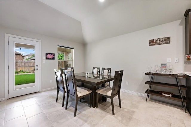 dining room featuring light tile patterned flooring, baseboards, and lofted ceiling