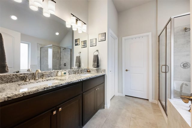bathroom with double vanity, a sink, vaulted ceiling, and a shower stall