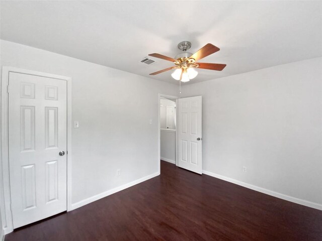 empty room featuring baseboards, ceiling fan, wood finished floors, and visible vents