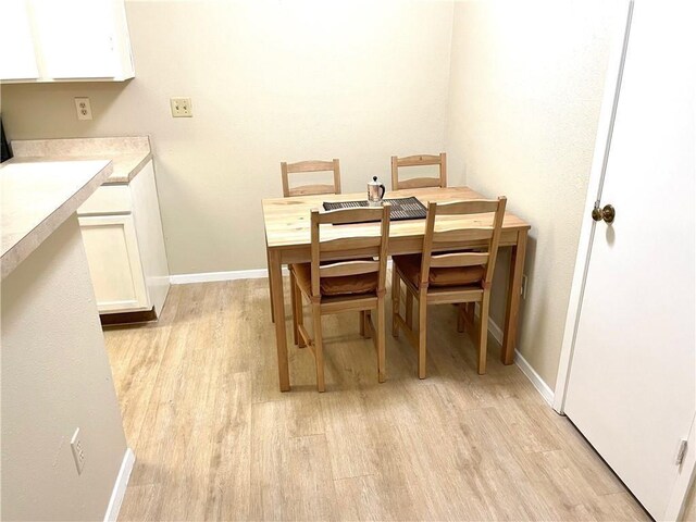 dining area with baseboards and light wood-type flooring