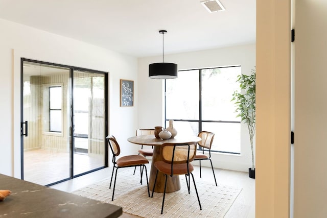 dining area with visible vents, a wealth of natural light, and light wood-type flooring