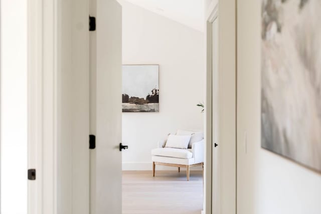 corridor featuring baseboards and wood finished floors