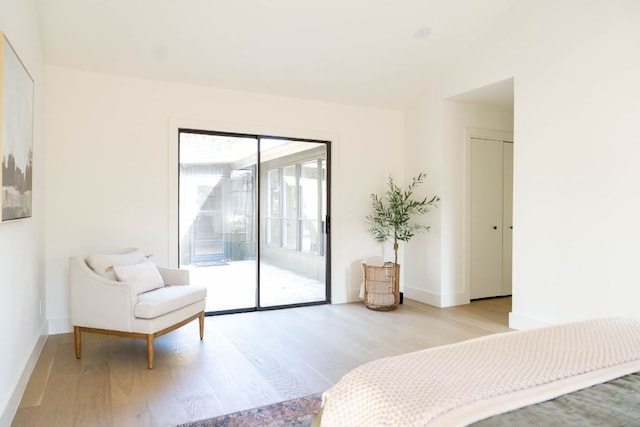 bedroom with access to outside, baseboards, and wood finished floors