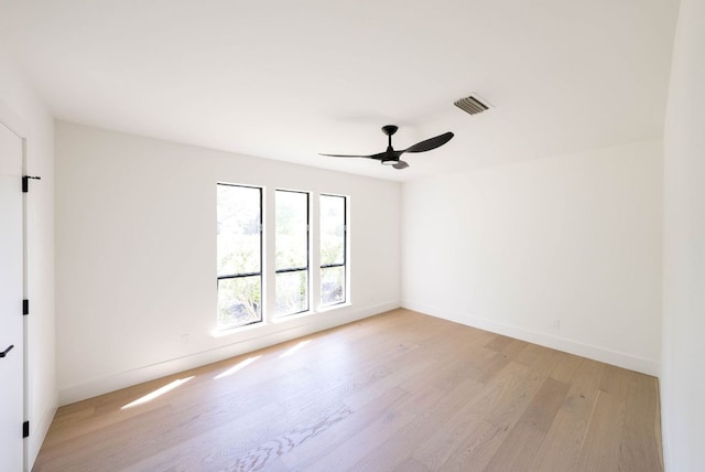 unfurnished room with baseboards, a ceiling fan, light wood-style flooring, and visible vents
