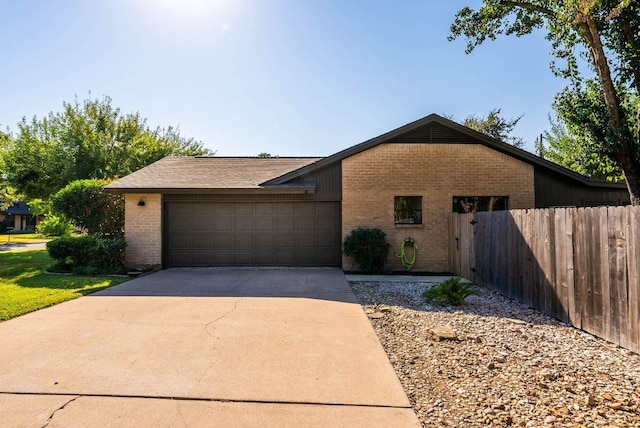 ranch-style home featuring brick siding, a garage, fence, and driveway