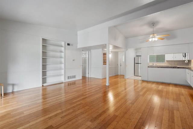 1304 Mariposa Dr Unit 231, Austin, TX 78704 - unfurnished living room featuring light wood-type flooring, ceiling fan, and built in features