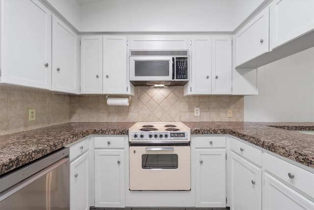 kitchen with white cabinets, backsplash, stainless steel appliances, and dark stone countertops