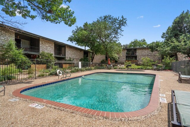 community pool featuring a patio and fence