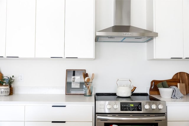 5731 Wellington Dr, Austin, TX 78723 - kitchen with wall chimney exhaust hood, electric range, white cabinetry, and light countertops