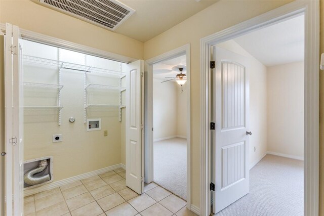 corridor with baseboards, visible vents, light carpet, and light tile patterned floors