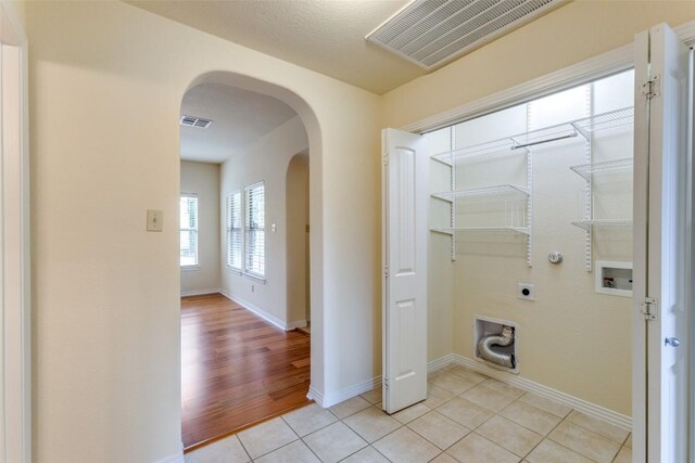laundry room featuring washer hookup, laundry area, arched walkways, hookup for an electric dryer, and visible vents
