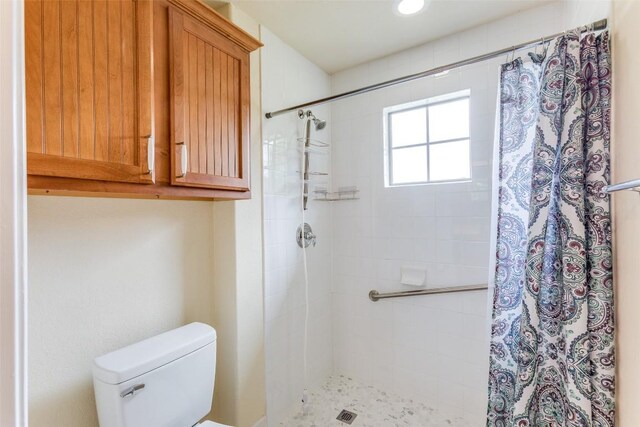 full bathroom with toilet and tiled shower