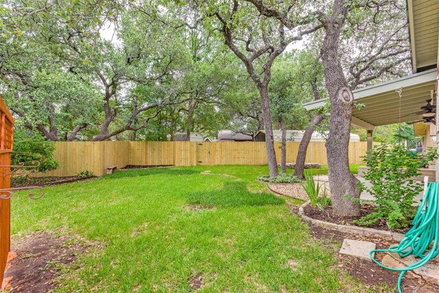 view of yard featuring a fenced backyard and a ceiling fan
