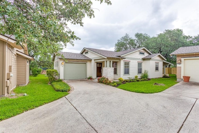 ranch-style house with a garage, a front lawn, fence, roof with shingles, and driveway