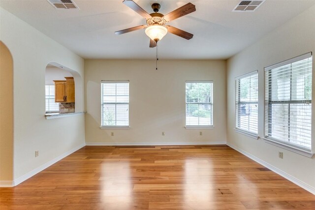 spare room with arched walkways, visible vents, and light wood-style flooring