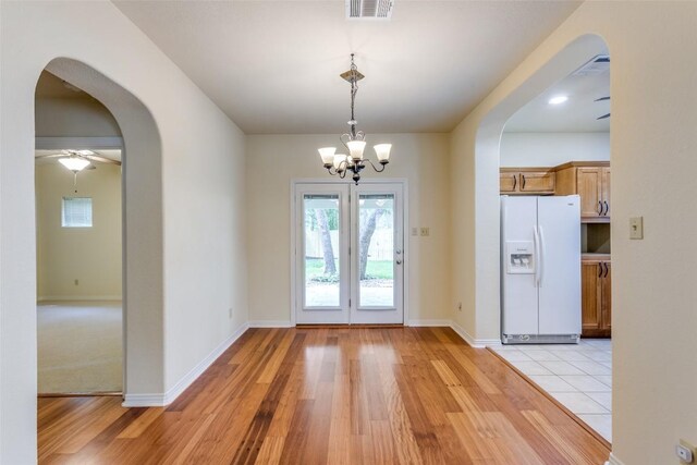 doorway with visible vents, arched walkways, and a healthy amount of sunlight