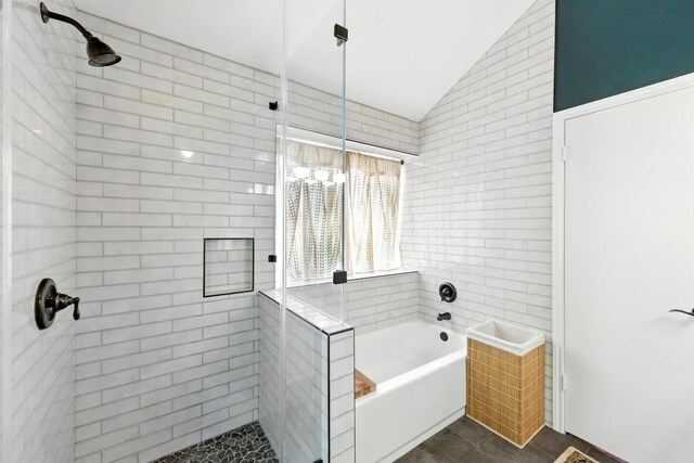 bathroom featuring a bath, vaulted ceiling, and a shower stall