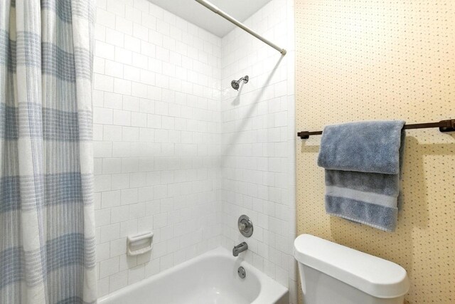 bathroom with toilet and shower / tub combo