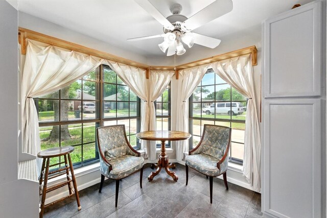 sitting room with baseboards and ceiling fan