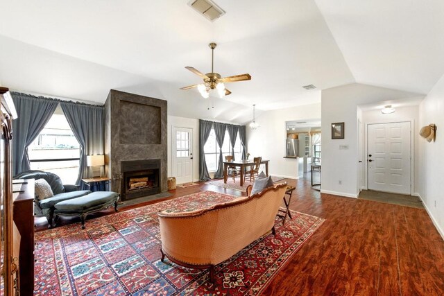 living room featuring visible vents, a ceiling fan, wood finished floors, and vaulted ceiling