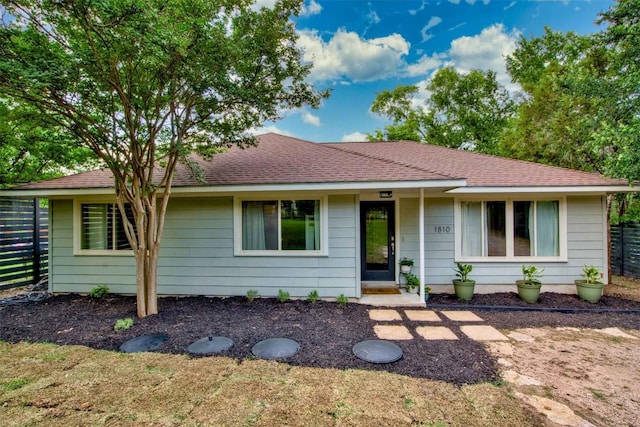 view of front of house with fence and a shingled roof