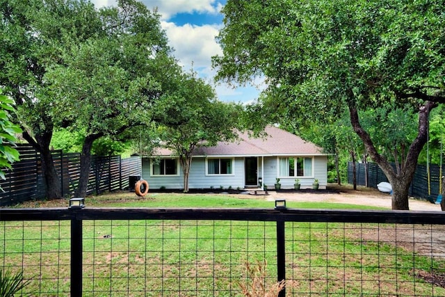 ranch-style house featuring fence and a front yard