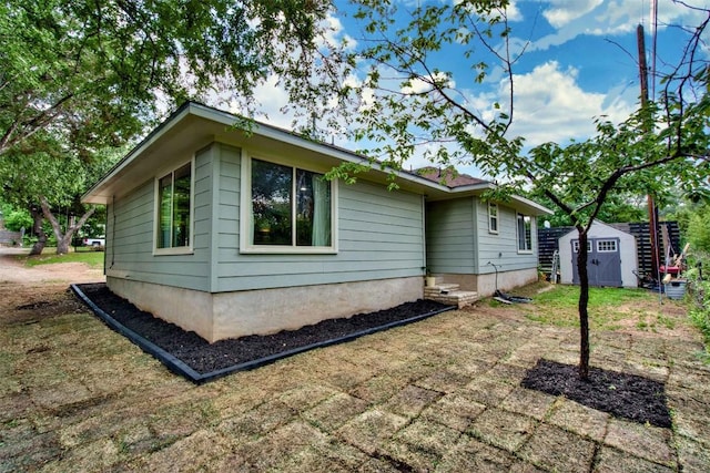 view of side of home featuring a storage unit and an outdoor structure