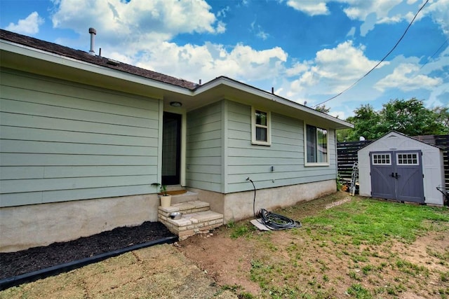 back of property with entry steps, a storage unit, and an outbuilding