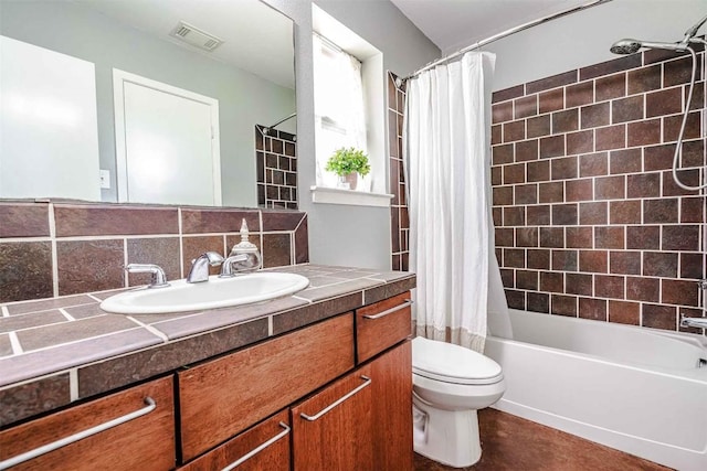 bathroom featuring shower / tub combo, vanity, toilet, and visible vents