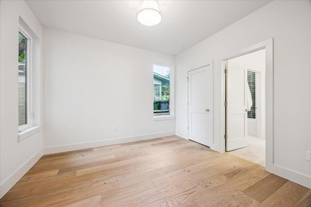 4708 Philco Dr, Austin, TX 78745 - unfurnished bedroom featuring multiple windows, light wood-style floors, and baseboards