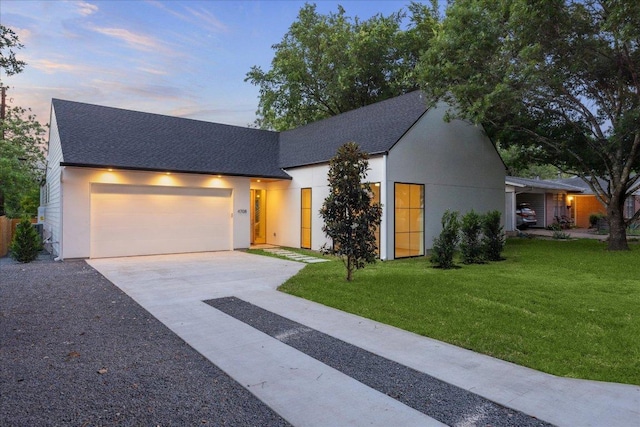 view of front facade featuring a garage, stucco siding, a shingled roof, concrete driveway, and a lawn