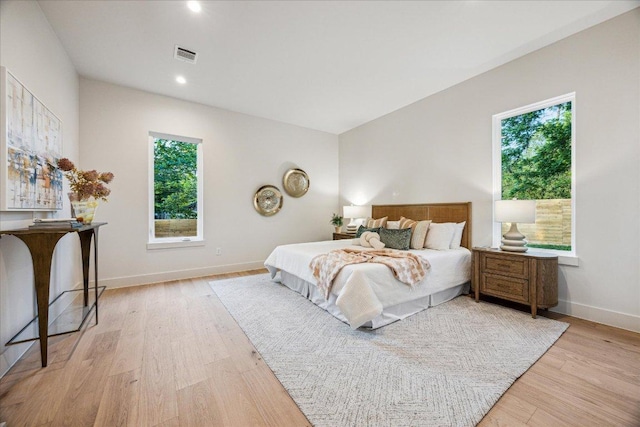 bedroom with baseboards, recessed lighting, light wood-style flooring, and visible vents