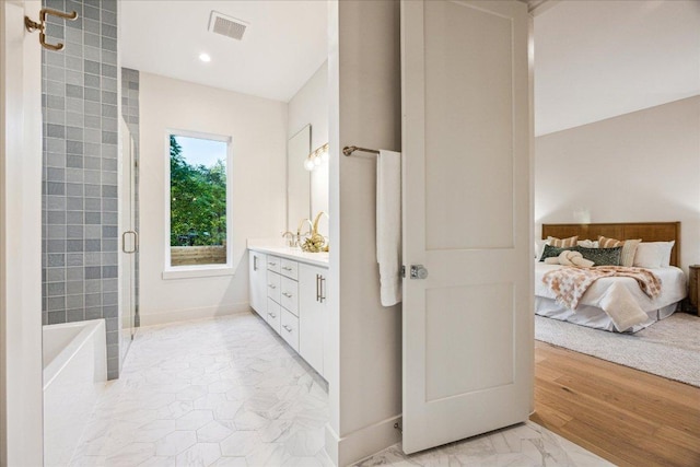 ensuite bathroom featuring visible vents, a stall shower, vanity, baseboards, and connected bathroom