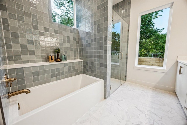 full bathroom with marble finish floor, a bath, a wealth of natural light, and a shower stall