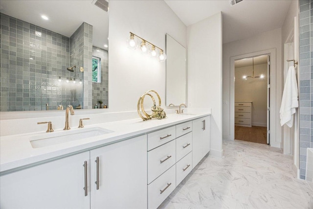 full bathroom with visible vents, a sink, walk in shower, and double vanity