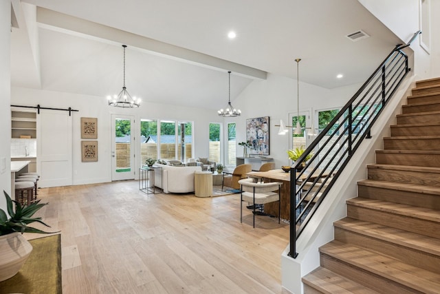 4708 Philco Dr, Austin, TX 78745 - living area with a barn door, a chandelier, stairway, beamed ceiling, and light wood-style flooring
