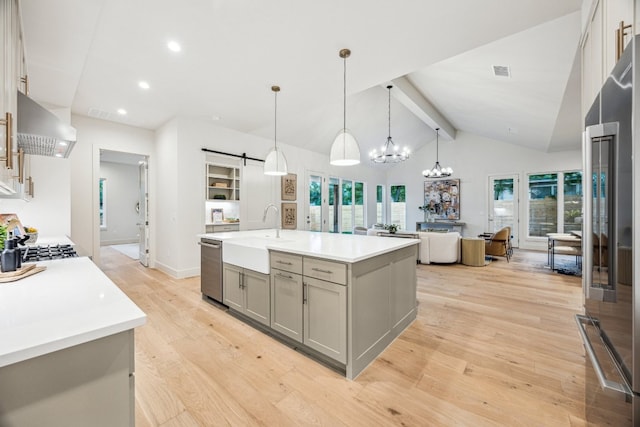 4708 Philco Dr, Austin, TX 78745 - kitchen with a sink, wall chimney range hood, gray cabinets, appliances with stainless steel finishes, and light wood-style floors