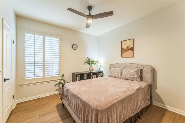 bedroom with baseboards, ceiling fan, and wood finished floors