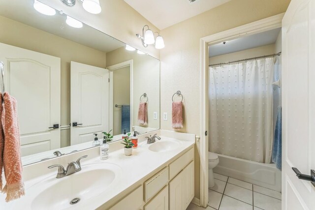 full bath featuring a sink, tile patterned floors, toilet, and double vanity