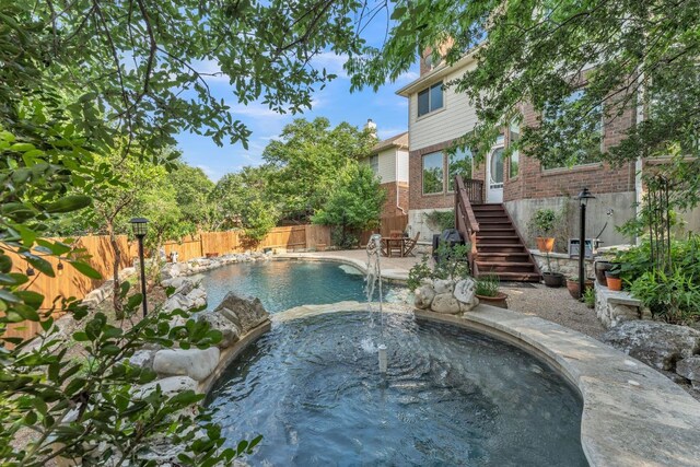 view of swimming pool with an in ground hot tub, a fenced in pool, a fenced backyard, and stairs