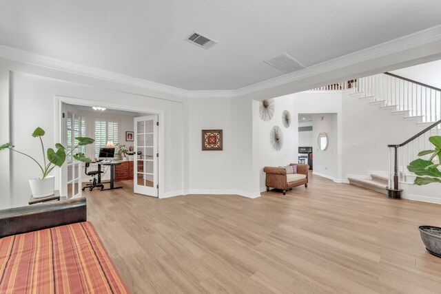 sitting room with visible vents, ornamental molding, stairway, and light wood-style floors