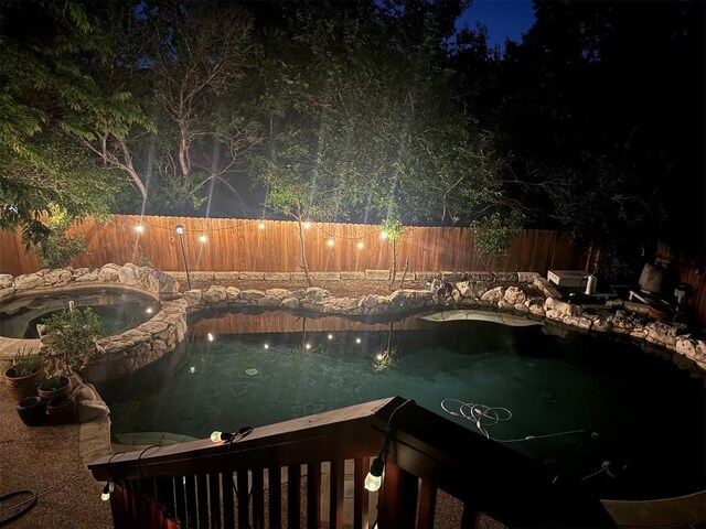 view of swimming pool with a fenced backyard, a fenced in pool, and an in ground hot tub