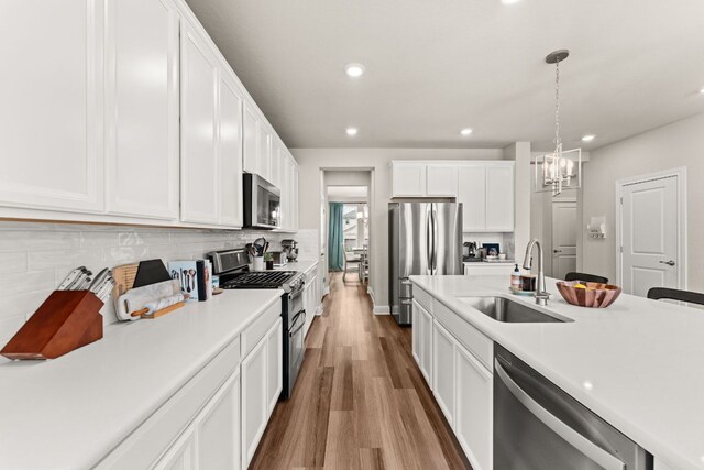 kitchen featuring a sink, light countertops, stainless steel appliances, and wood finished floors