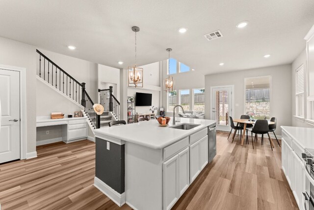 kitchen featuring an inviting chandelier, a sink, light wood-style flooring, stainless steel appliances, and visible vents
