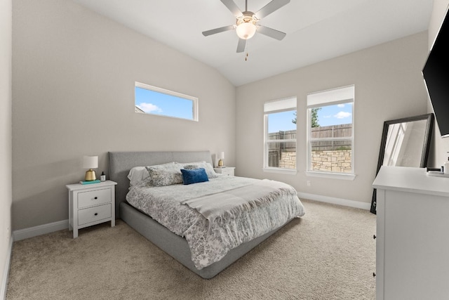 bedroom with baseboards, multiple windows, lofted ceiling, and light carpet