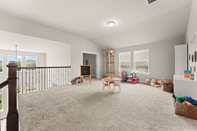 playroom featuring vaulted ceiling, a healthy amount of sunlight, and carpet